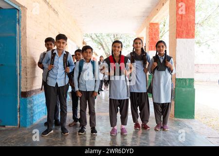 Glückliche Gruppe indischer Landkinder in Schuluniform stehend in der Kamera im Schulkorridor. Bildungskonzept Stockfoto