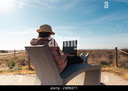 Frau mit Laptop, arbeitet draußen in Barcelona. Stockfoto