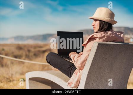 Frau mit Laptop, arbeitet draußen in Barcelona. Stockfoto
