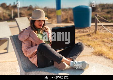Frau mit Laptop, arbeitet draußen in Barcelona. Stockfoto
