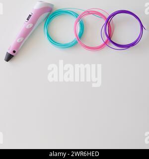 3D-Stift und Kit mit farbigen Kunststofffilamenten auf weißem Tisch mit Copyspace Stockfoto