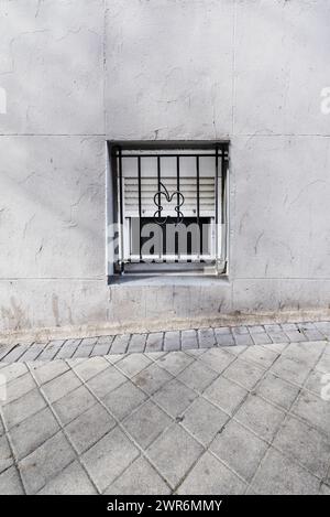 Ein kleines Fenster im Erdgeschoss auf der Straße eines Hauses im Untergeschoss Stockfoto