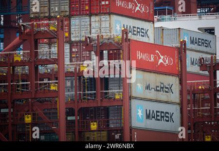 Hamburg, Deutschland. März 2024. Im Hamburger Hafen werden Container auf einem Containerschiff gestapelt. Der Deutsche Reederverband (VDR) informiert auf seiner Jahrespressekonferenz am 12. März in Hamburg über die geopolitische Situation und die Bedeutung sicherer Seeverkehrswege, aktuelle Zahlen und Entwicklungen in der deutschen Seeschifffahrt sowie Maßnahmen zum Klimaschutz und zur Sicherung von Fachkräften. Quelle: Christian Charisius/dpa/Alamy Live News Stockfoto