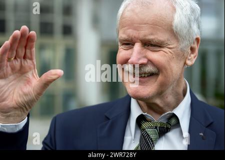 Senior Mann im Anzug, der fröhlich mit der Hand winkt. Stockfoto