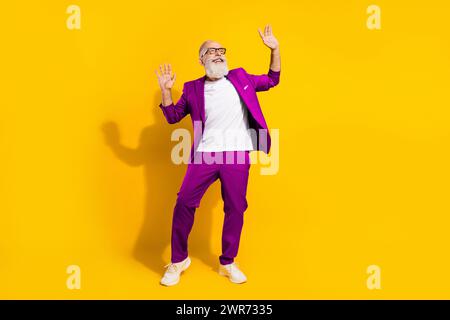 In voller Länge Körpergröße Foto des Mannes mit weißem Bart lachen tanzen überglücklich gelben Hintergrund Stockfoto