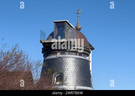 Die wichtigsten Geschichten einer umgebauten Mühle in Aldeburgh, gegen den Sonnenschein des Frühjahrs und den blauen Himmel, Suffolk, England, März 2024. Stockfoto