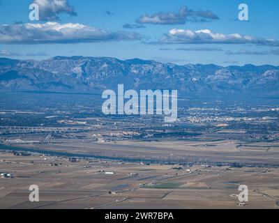 Luftaufnahme der Reisfelder des Ebro-Deltas im Vordergrund. Im Hintergrund die Berge der Serra de Cardó (Tarragona, Katalonien, Spanien) Stockfoto