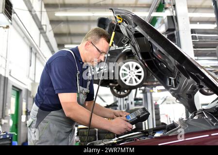 Kfz-Mechaniker in einer Werkstatt - Motor Reparatur und Diagnose an einem Fahrzeug Stockfoto
