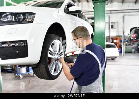 Automechaniker Änderungen die Reifen des Fahrzeugs in der Werkstatt Stockfoto