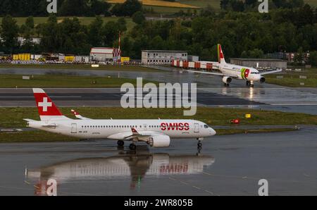 Ein Airbus A220-300 von Swiss International Airlines wartet bis er auf die Startbahn kann. Registrierung HB-JCS. Dahinter rollt ein Airbus A319-111 von Stockfoto