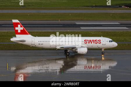 Ein Airbus A320-214 von Swiss International Airlines startete rollt nach einer heftigen Gewitterfront zur Startbahn. Registrierung HB-JLR. (Zürich, Schw Stockfoto