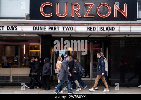 Die Leute warten draußen und passieren das Curzon Soho Kino auf der Shaftesbury Avenue, dem Flaggschiff der Art-House-Kinokette, in der die Filme Dune 2 und Red Island derzeit am 6. März 2024 in London, Großbritannien, gezeigt werden. Curzon Cinemas bieten auch einen Video-on-Demand-Service, Curzon Home Cinema. Stockfoto