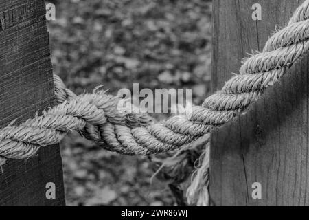 Ein geknüpftes Seil hält ein Landtor geschlossen. Konzepte, geschlossen, gesperrt, Sicherheit, Sicherheit, Prävention, psychische Probleme, Texturen. Stockfoto