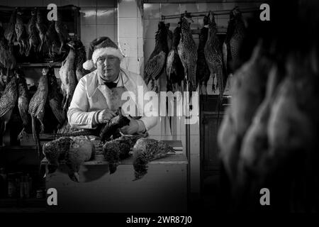 21/12/2023 Mick Hulme beginnt 600 Fasane im Keller unter seinem Laden in Ashbourne, Derbyshire zu pflücken. Mick, 65, ist die dritte Generation von h Stockfoto