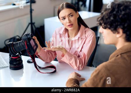 Eine Fotografin rezensiert Bilder mit männlichem Model während der Studioaufnahme Stockfoto