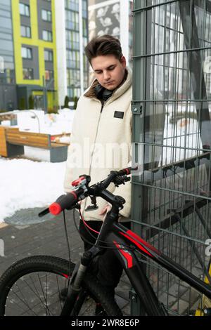 Ein hübscher junger Kerl fährt ein Leihfahrrad Stockfoto