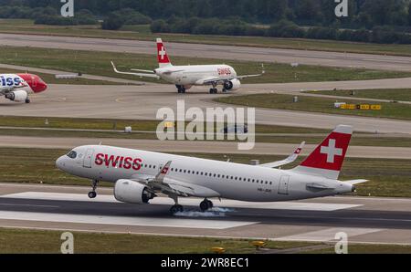 Vor einem hefitgen Gewitterfront landet ein Airbus A320-271N (Airbus A320neo) von Swiss International Airlines auf dem Flughafen Zürich. Dahinter-Rolle Stockfoto