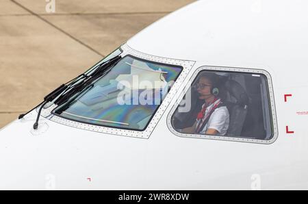 Eine Pilotin im Cockpit eines Embraer 190-E2 von Helvetic Airways bei Ihrer Arbeit nach der Landung auf dem Flughafen Zürich. (Zürich, Schweiz, 24.05. Stockfoto