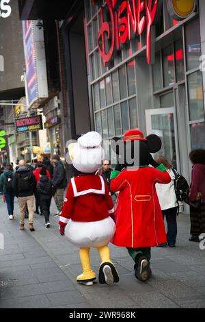 Mickey Mouse und Donald Duck schlendern am Disney Store entlang des Broadway am Times Square, New York City. Stockfoto