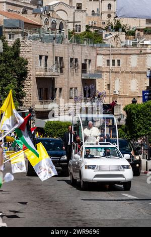 Papst Franziskus reitet auf einem offenen Vahikel und begrüßt Pilger auf der Hauptstraße von Betlehem, Palästina am 25. Mai 2014. Papst Franziskus unternahm die Reise nach Betlehem als eine seiner ersten Reisen im Amt. Er unterstützt ein Friedensabkommen zwischen Isreal und Palästinensern. Stockfoto