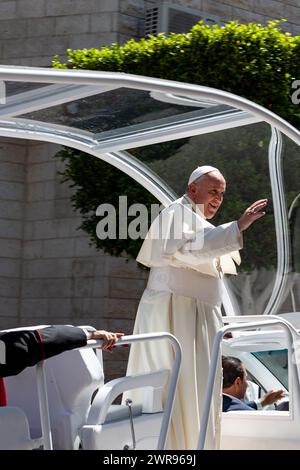 Papst Franziskus reitet auf einem offenen Vahikel und begrüßt Pilger auf der Hauptstraße von Betlehem, Palästina am 25. Mai 2014. Papst Franziskus unternahm die Reise nach Betlehem als eine seiner ersten Reisen im Amt. Er unterstützt ein Friedensabkommen zwischen Isreal und Palästinensern. Stockfoto