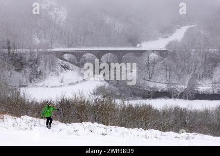 12/2023 Ein Wanderer trotzt den winterlichen Bedingungen, nachdem er über Nacht in Monsal Head, nahe Bakewell, im Derbyshire Peak District, stark schneebedeckt ist. Alle Stockfoto