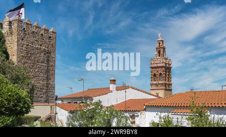 Torreón siglo XIII con bandera de la orden templaria y campanario barroco iglesia de san Miguel Arcángel en la Villa de Jerez de los Caballeros, Españ Stockfoto