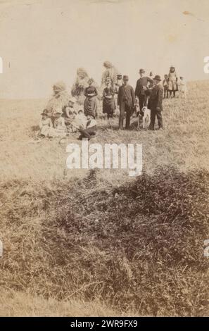 Gruppenporträt von Männern, Frauen und Kindern in der Nähe von Heuschollen, dieses Foto ist Teil eines Albums., anonym, 1860 - 1900, Papier, Albumenabdruck, Höhe 111 mm x Breite 74 mm, Foto Stockfoto