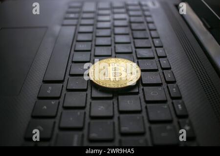 Ich habe einen Bitcoin auf die Tastatur meines Laptops gelegt. Ist es an der Zeit, mehr Bitcoin zu kaufen? Stockfoto
