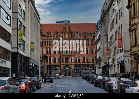 Historische europäische Stadtstraße mit traditioneller Architektur und geparkten Autos unter bewölktem Himmel in Leeds, Großbritannien. Stockfoto