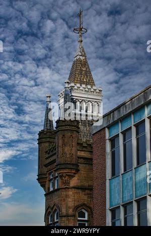 Historischer Turm mit Turm vor einem dramatischen bewölkten Himmel, der mit moderner Gebäudefassade in Leeds, Großbritannien, verglichen wird. Stockfoto