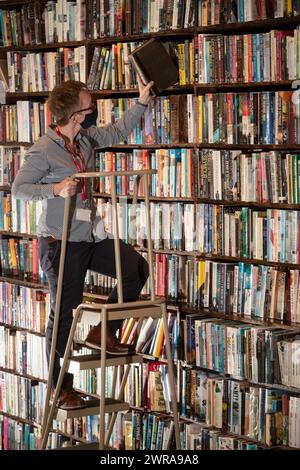 05/21 Melanie Duffill-Jeffs sucht nach Büchern, die repariert werden müssen. Buchkonservatoren kehren zu der mühsamen Reparatur antiker Bücher in br Stockfoto