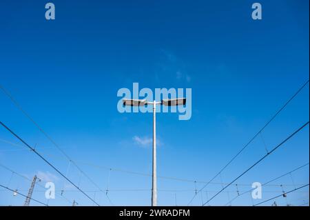 Brüssel Nord, Region Brüssel Hauptstadt, Belgien, 27. Februar 2024 - Stromkabel und Straßenlaterne des Bahnhofs vor blauem Himmel Stockfoto