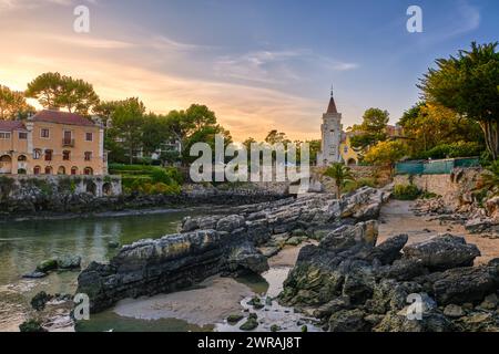 Farbenfroher Sonnenuntergang über dem Museum von Conde de de Castro Guimaraes, Cascais, Portugal. Wunderschönes Gebäude in malerischer Lage, neben Gezeitenpool, Sandstrand, felsigen Ufern und Brücke, stilisiert als Manueline Castle. Stockfoto