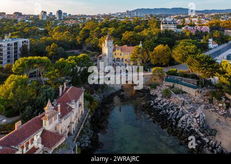 Farbenfroher Sonnenuntergang über dem Museum von Conde de de Castro Guimaraes, Cascais, Portugal. Wunderschönes Gebäude in malerischer Lage, neben Gezeitenpool, Sandstrand, felsigen Ufern und Brücke, stilisiert als Manueline Castle. Stockfoto