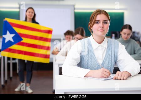 Geografie-Unterricht in der Schule - der Lehrer spricht über Katalonien und hält die Flagge in seinen Händen Stockfoto