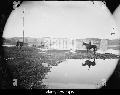 Berlin (heute Braunschweig), Md Pontonbrücke und Ruinen der Steinbrücke über den Potomac (1861 zerstört), Foto zeigt Telegrafenmast links und Pontonbrücke, die von Unionstruppen über den Potomac River in Barry, Maryland (früher Berlin und später Brunswick, MD.) gebaut wurde. Diese Aussicht von Virginia in Richtung Stadt zeigt ein Pferd und Reiter mit ihrer Reflexion im Wasser und umfasst auch die Steinpfeiler einer Brücke, die 1861 von der Konföderierten Armee zerstört wurde. Die Stadt liegt etwa 30 km südlich von Antietam Stockfoto