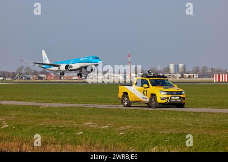 Vogelschutzfahrzeug K1 Patrouillen und KLM Cityhopper Embraer E195-E2 mit Kennzeichen PH-NXI landet auf der Polderbaan, Amsterdam Schiphol Airport in Stockfoto