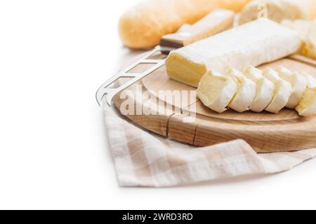 Kunstvoll angeordneter Käse auf Holzbrett mit Tuch und Messer, die die Kunst der Essenspräsentation hervorheben Stockfoto