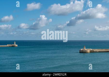 Die beiden Leuchttürme markieren den Eingang zum Grand Harbour in Valletta, Malta, unter einem dramatischen Himmel Stockfoto