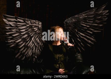 Eine Frau mit dunkler Vergangenheit findet Trost in einem Glas Wein Stockfoto