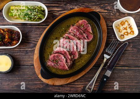 Geschnittenes gegrilltes Filet, das nach dem Anbraten auf dem Grill mit Saucen aromatisiert wird Stockfoto