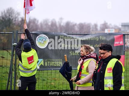 12. März 2024, Nordrhein-Westfalen, Dortmund: Gewerkschaftsmitglieder gehen an einem Banner mit der Aufschrift „Getting Ahead #TVN2024“ und der Forderung nach „mehr Entlastung für Arbeitnehmer“ vorbei. Streiks im öffentlichen Nahverkehr in Nordrhein-Westfalen drohen. Die gewerkschaft Verdi Nordrhein-Westfalen hat die Tarifverhandlungen über die Arbeitsbedingungen von rund 30.000 Beschäftigten in kommunalen Verkehrsunternehmen für gescheitert erklärt. Die dritte Verhandlungsrunde im Tarifstreit hatte am 11.03.2024 in Dortmund begonnen. Ursprünglich war dies auch für 12.03.2024 geplant Stockfoto