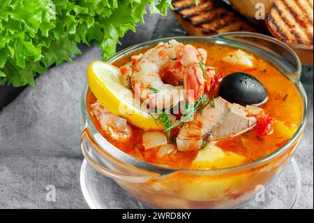 Köstliche Bouillabaisse-Suppe wird aus den frischesten Meeresfrüchten aus nächster Nähe mit Baguette-Croutons zubereitet. Lachssuppe mit Sahne, Kartoffeln, Karotten und Pars Stockfoto