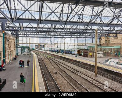 Passagiere warten auf einen Zug am Bahnsteig am Bahnhof in Carlisle, England. Stockfoto