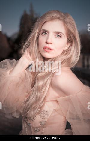 Hübsche Dame in Abendkleidung posiert im Schlosspark Stockfoto