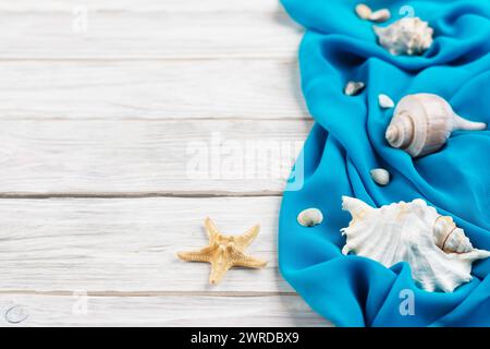 Muscheln, blauer Stoff und Seesterne auf weißen Dielen Urlaubsplanung Hintergrund flach liegen mit Kopierraum Stockfoto