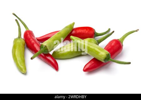 Haufen von ganzen frischen, rohen grünen und roten Paprika nahe oben isoliert auf weißem Hintergrund Stockfoto