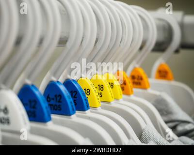 Babykleidung hängt in einem Kleiderschrank Stockfoto