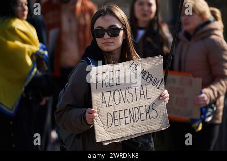 Ukrainische Frau hält ein Banner "Freie Azovstal-Verteidiger". Sei nicht still!“ Auf einer Demonstration zur Freilassung eines Gefangenen der Asow-Brigade aus dem russischen Gefängnis. Kiew - 10. März 2024 Stockfoto